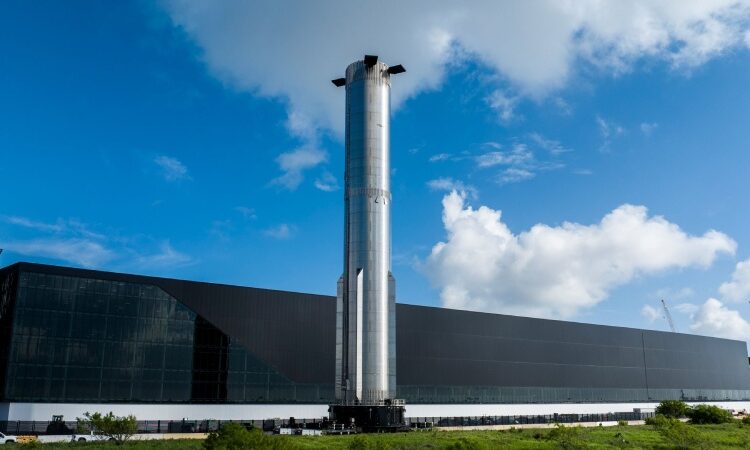 A huge Super Heavy booster is rolled onto the launch pad ahead of the launch of Starship Flight 8 by SpaceX